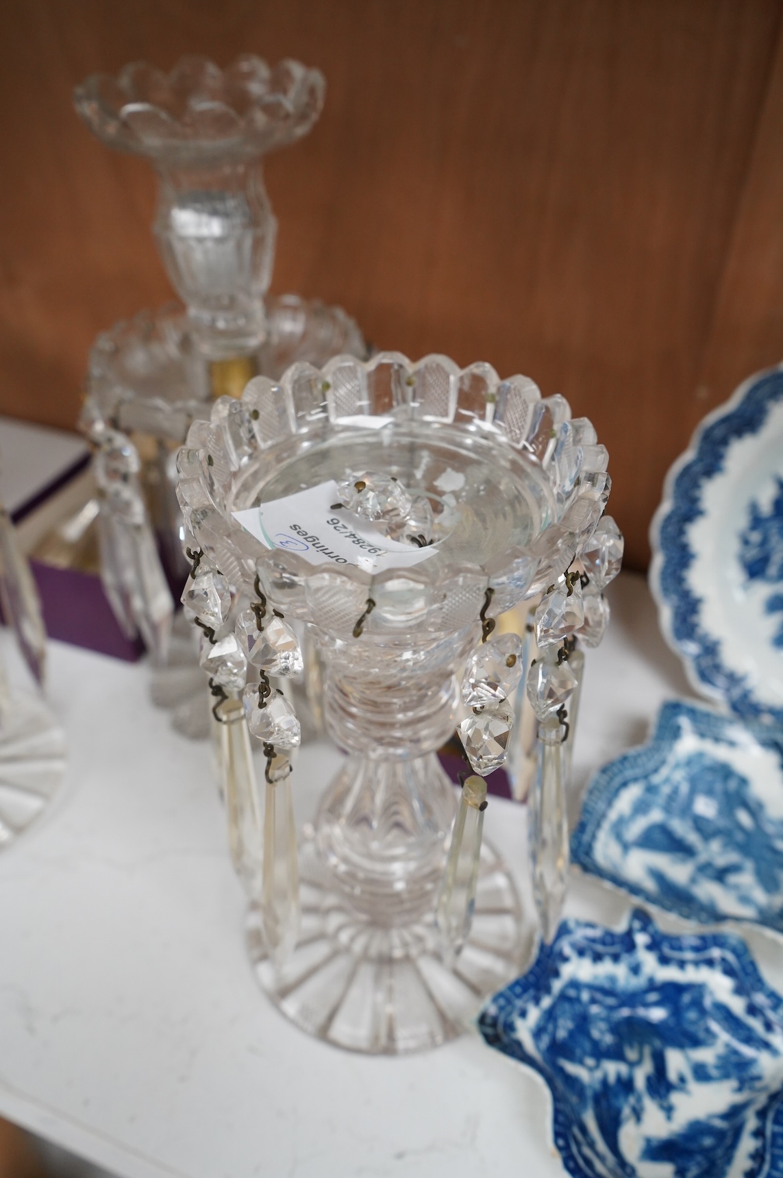 A pair of Victorian cut glass lustre candlesticks and one larger candlestick, 24cm high